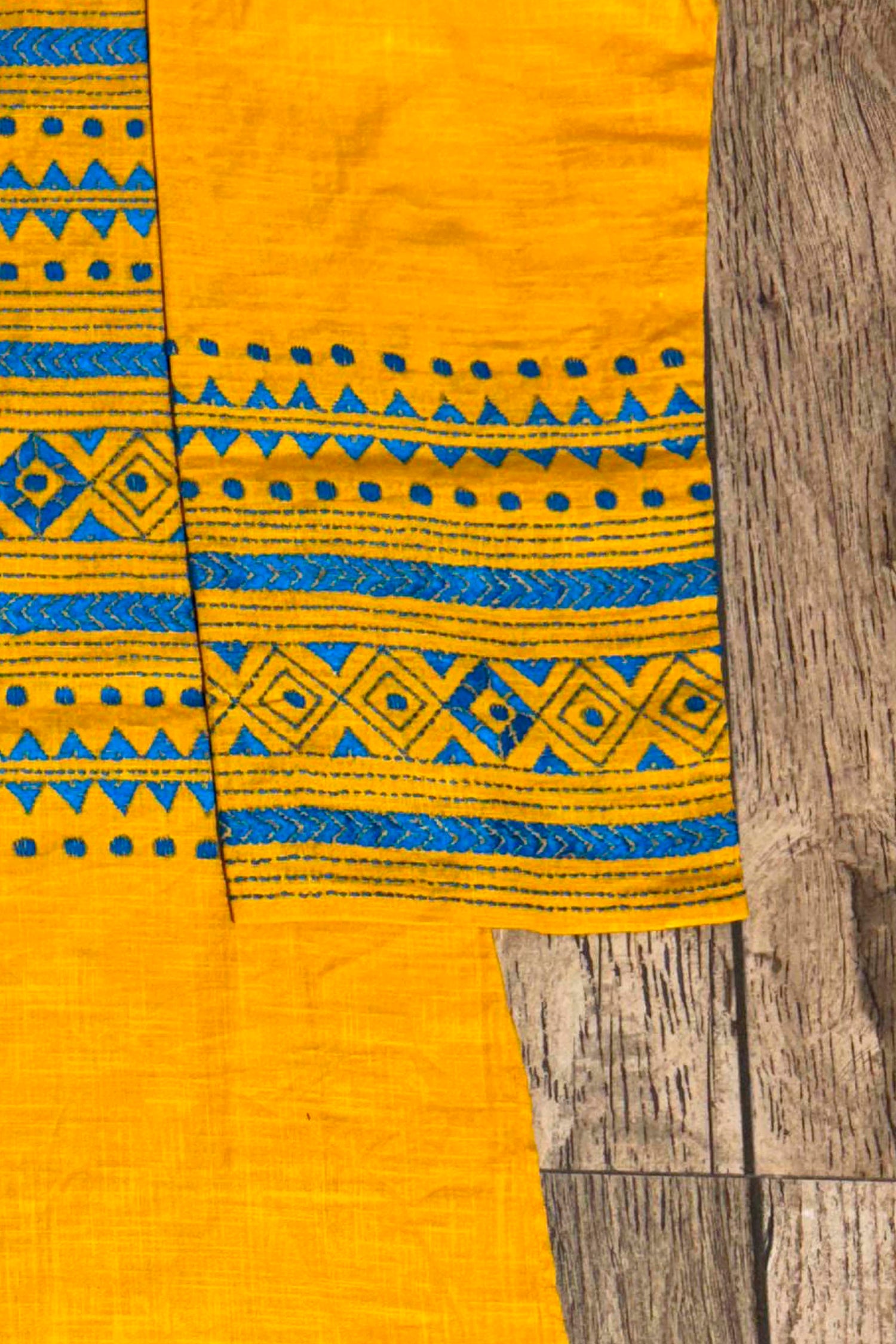 Yellow fabric with blue patterns on a wooden surface