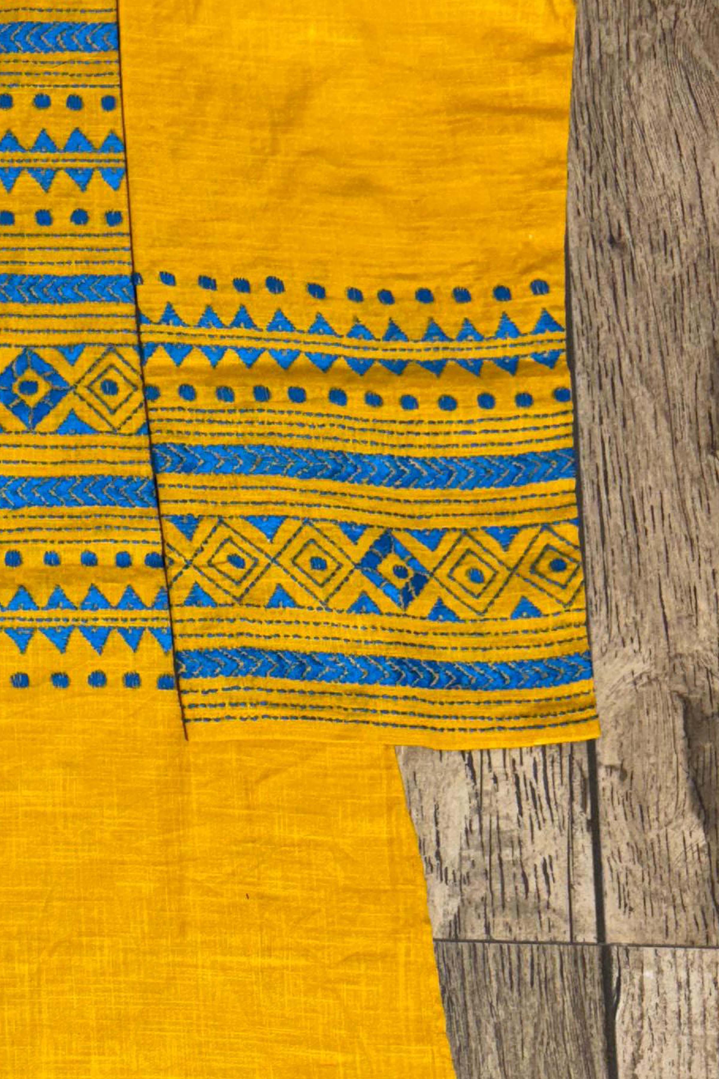 Yellow fabric with blue patterns on a wooden surface