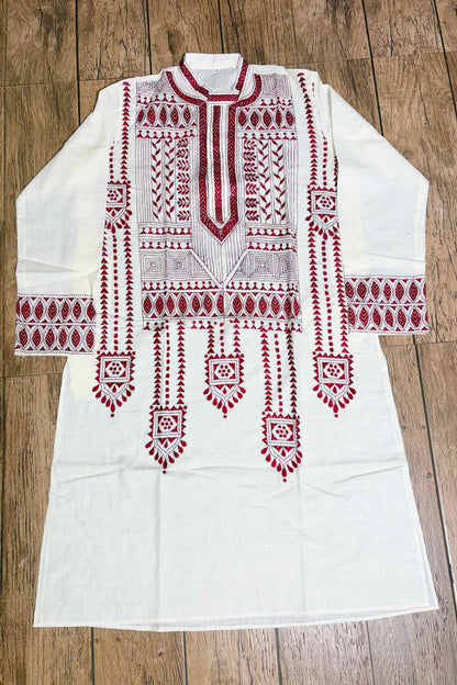 White embroidered kurta with red patterns on a wooden surface